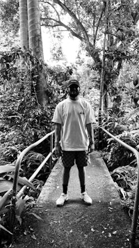 a man standing on a bridge in the jungle